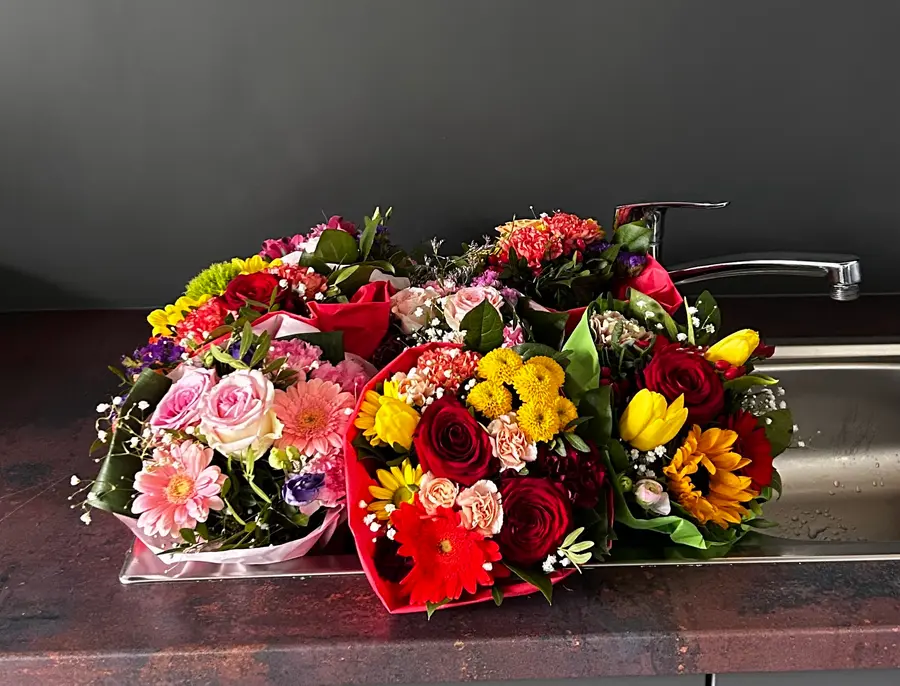 Mehrere bunte Sträuße mit Rosen, Gerbera, Tulpen und Sonnenblumen